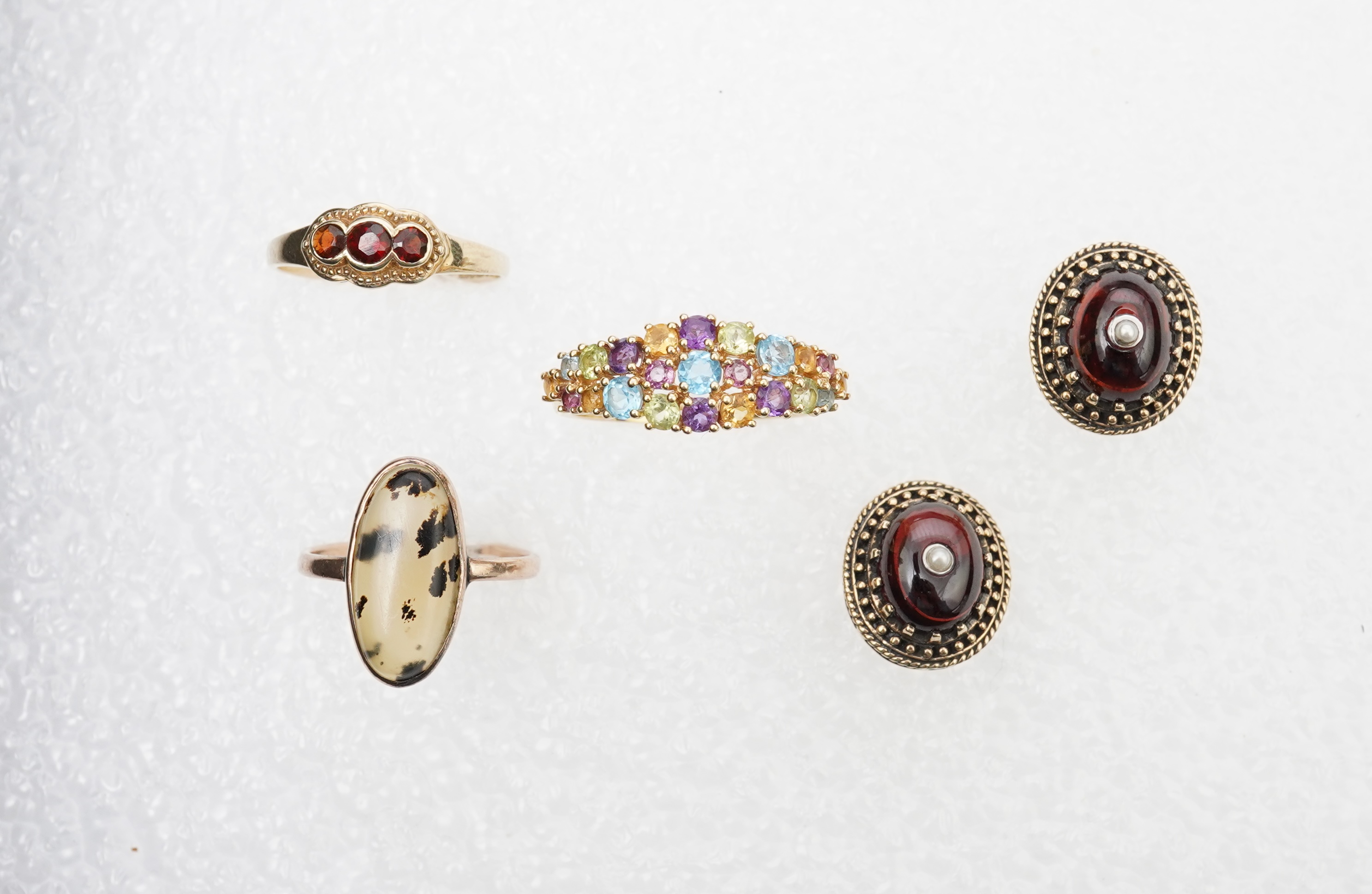 A modern 18ct gold and multi gem set cluster ring, size P, together with two 9ct rings including moss agate and a pair of 9ct gold and seed pearl set cabochon garnet ear studs.